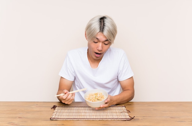 Jonge Aziatische man met ramen in een tafel