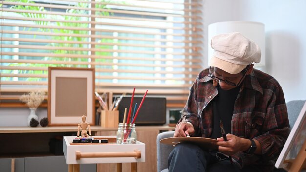 Jonge Aziatische man schilderen op canvas in zijn atelier.