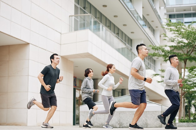 Jonge Aziatische mensen die 's ochtends op straat rennen, trainen voor de halve marathon