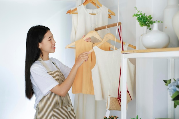 Jonge Aziatische ondernemer die kleding in kleine bedrijven controleert