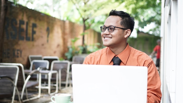 Jonge aziatische ondernemers die laptop bekijken