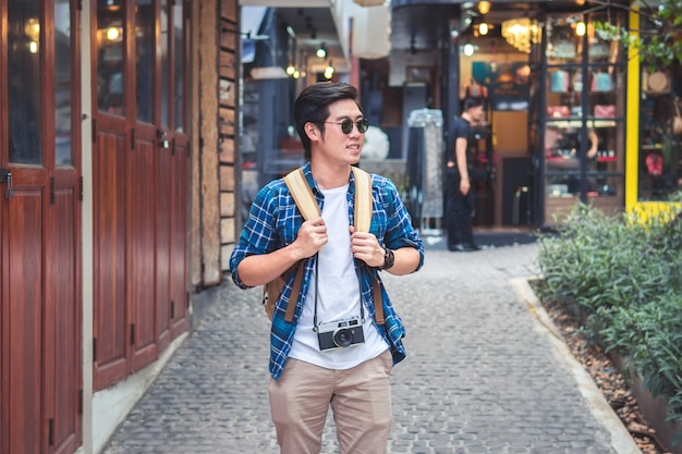 Jonge Aziatische reizende backpacker in straat stad en wandelen op zoek naar kant, Thailand