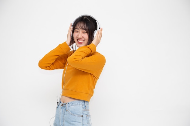 Jonge Aziatische schoonheidsvrouw die muziek luistert met een koptelefoon in de songtoepassing van de afspeellijst op smartphone geïsoleerd op een witte achtergrond