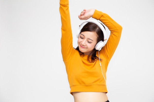 Jonge aziatische schoonheidsvrouw het luisteren muziek met hoofdtelefoons