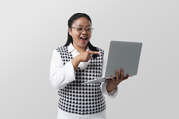 Jonge Aziatische student vrouw met laptop glimlachend gelukkig wijzend met hand en vinger