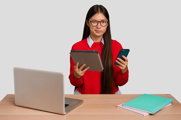 Jonge Aziatische student vrouw op een werkplek met een laptop geïsoleerd