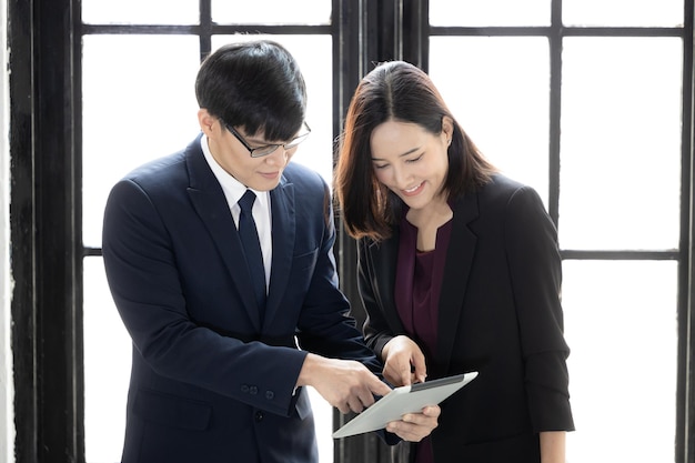 Jonge Aziatische succesvolle opstartende kleine zakenzakenman en zakenvrouwpartners Zakenman en zakenvrouw die digitale tablet samen gebruiken Opstarten van de bedrijfseigenaar