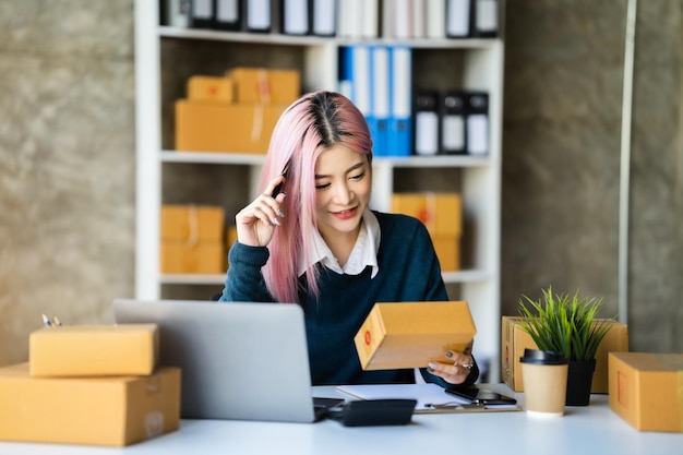 Jonge Aziatische vrouw denken en werken aan online verkopen in gezellig huis Moderne levensstijl van nieuwe generatie mensen