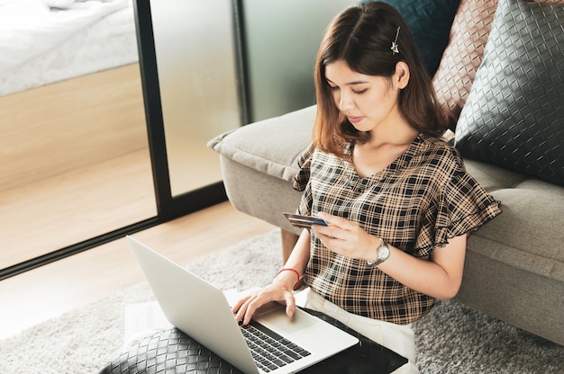 Foto jonge aziatische vrouw die creditcard gebruikt om online te winkelen