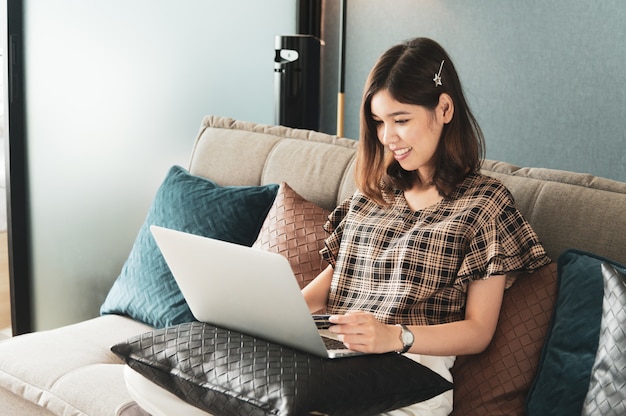 Foto jonge aziatische vrouw die creditcard gebruikt om online te winkelen