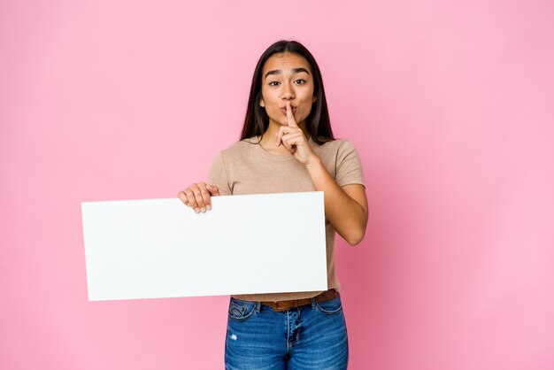 Jonge aziatische vrouw die een leeg document voor wit houdt iets dat een geheim houdt of om stilte vraagt.