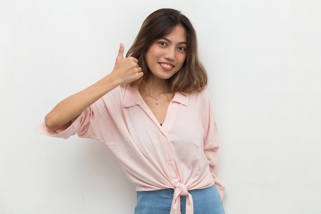 Jonge Aziatische vrouw die en OK teken met handgebaar glimlacht maakt