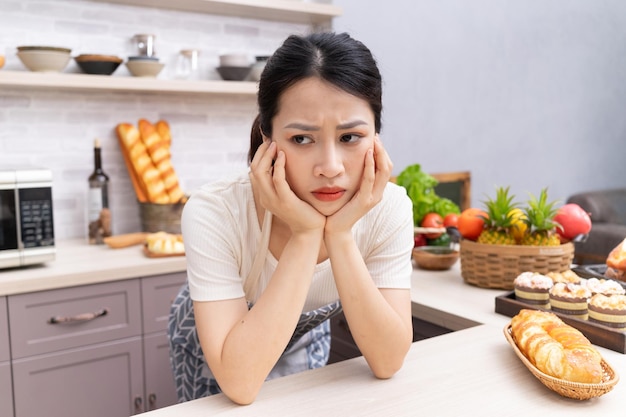 Jonge Aziatische vrouw die het huishouden beu isxA