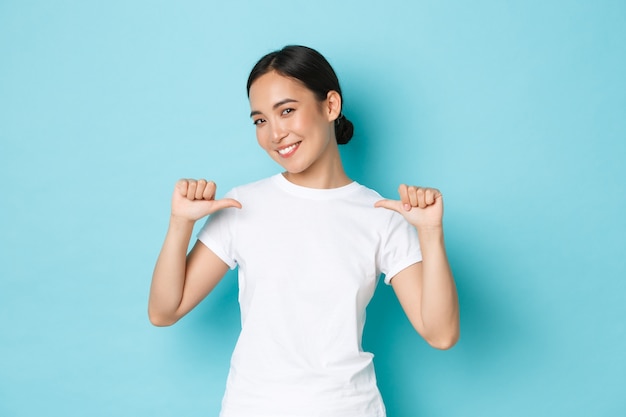 Jonge Aziatische vrouw die het toevallige T-shirt stellen draagt