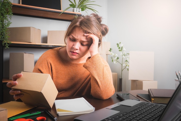 Jonge Aziatische vrouw die stress voelt of depressief is voor haar laptop online verkoopconcept