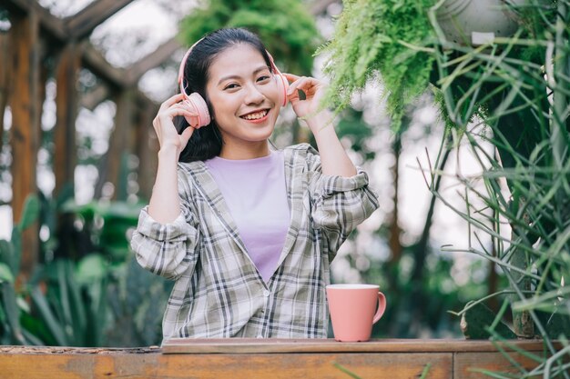 Jonge Aziatische vrouw die thee drinkt in de tuin