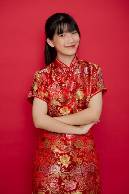 Jonge Aziatische vrouw die traditionele cheongsam draagt