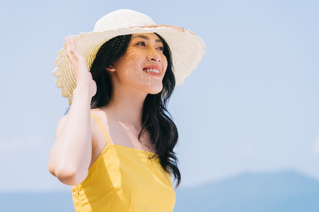 Jonge Aziatische vrouw die van de zomervakantie geniet op het strand