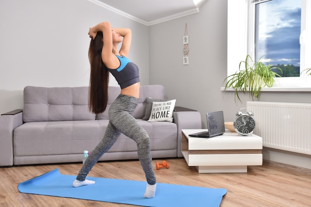 Jonge Aziatische vrouw die yoga thuis maakt.