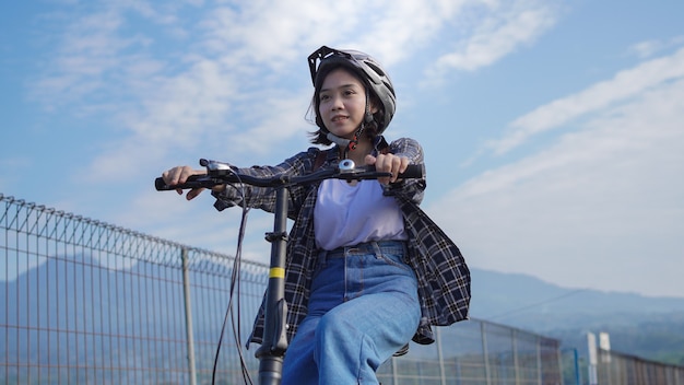 Jonge Aziatische vrouw fietst naar haar werk, ze is gelukkig en veilig