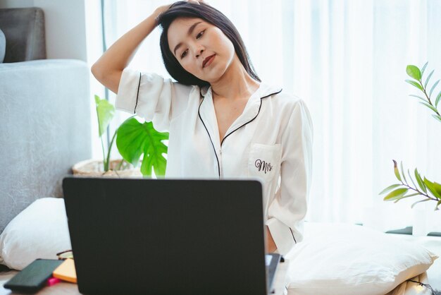 Jonge Aziatische vrouw freelance werkende zaken werken op laptop thuis, werken vanuit huis concept