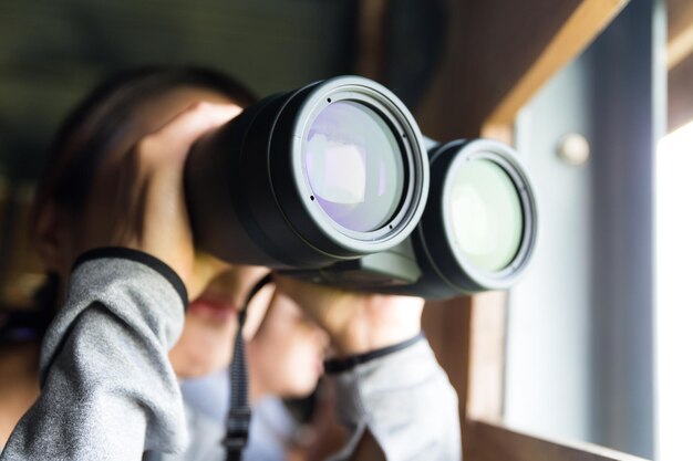 Foto jonge aziatische vrouw gebruikt de verrekijker om vogels te bekijken