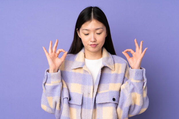 Jonge Aziatische vrouw geïsoleerd in zen pose