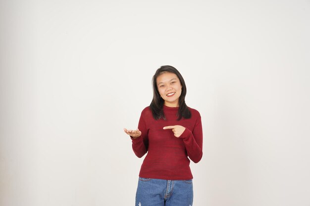 Jonge Aziatische vrouw in rood t-shirt die op een open palm kopieerruimte op een witte achtergrond toont en vasthoudt