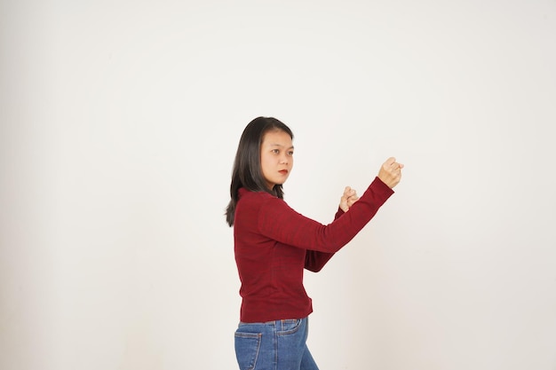 Jonge Aziatische vrouw in rood T-shirt Punching Fist to Fight geïsoleerd op witte achtergrond