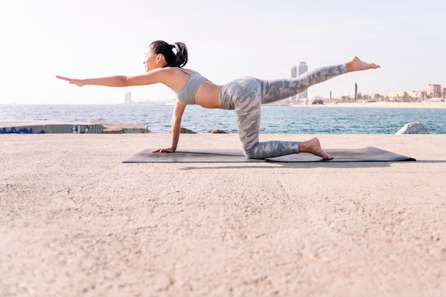 Foto jonge aziatische vrouw in sportkleding die yoga beoefent.