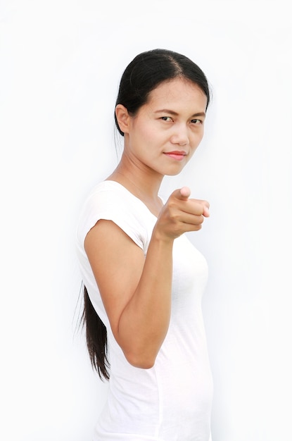 Jonge Aziatische vrouw in T-shirt die vinger richt op u op witte achtergrond