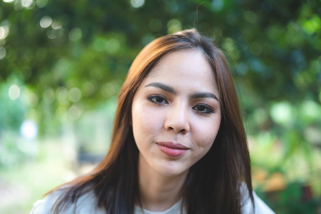 Jonge Aziatische vrouw is gelukkig en geniet in de tuin van de natuur om te ontspannen in een eco-vakantiecafé buiten