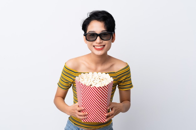 Jonge Aziatische vrouw met 3d glazen en holding een grote emmer popcorns