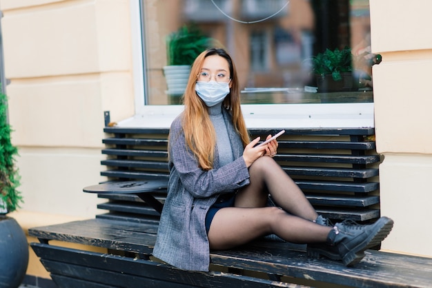 Jonge aziatische vrouw met chirurgische masker gezichtsbescherming. ze pendelt tussen huis en werkplek in de stad