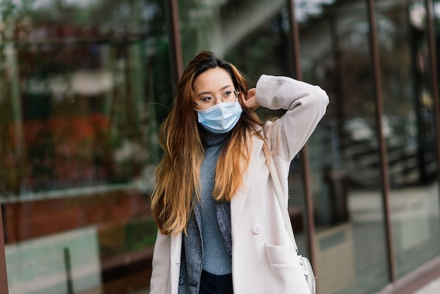 Jonge Aziatische vrouw met de chirurgische bescherming van het maskergezicht.