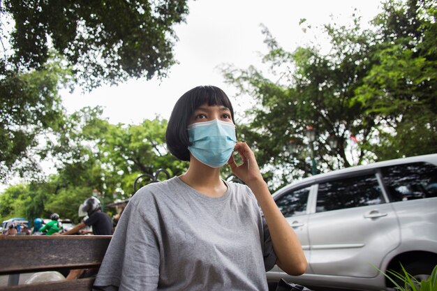 Jonge Aziatische vrouw met gezichtsmasker in openbare ruimtes Corona virus concept