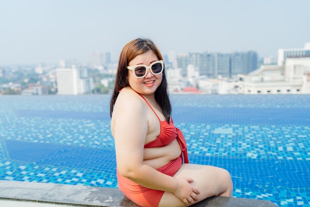 Jonge aziatische vrouw met overgewicht die zwempak draagt die in het zwembad ontspant Gelukkig plus size vrouw vrolijk grappig Vakantie Reizen in de zomer
