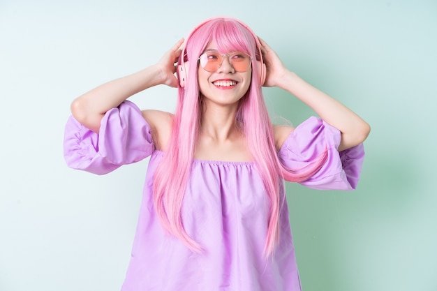 Jonge Aziatische vrouw met roze haar die zich voordeed op groene achtergrond