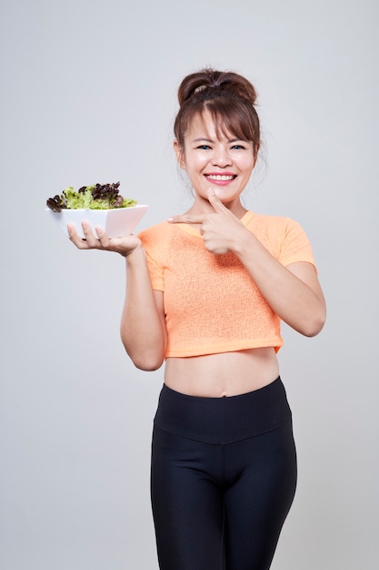 Jonge Aziatische vrouw met salade