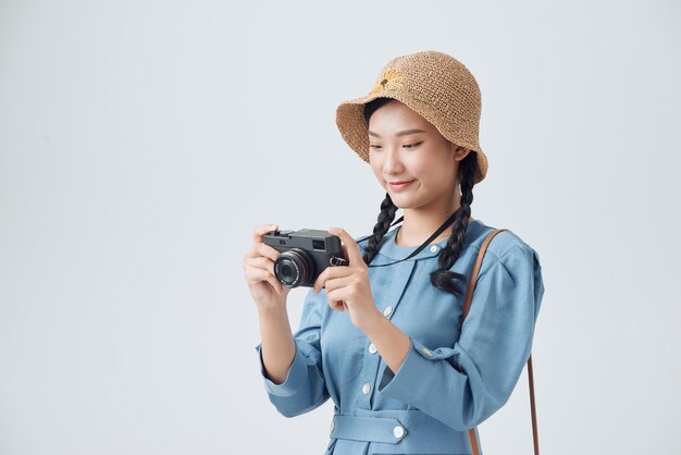 Jonge Aziatische vrouw met vintage camera geïsoleerd op een witte achtergrond