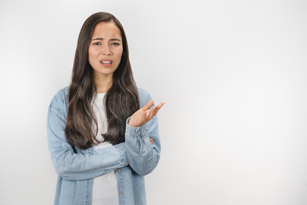 Jonge Aziatische vrouw ongelukkig omdat ze iets niet begrijpt over een witte geïsoleerde achtergrond