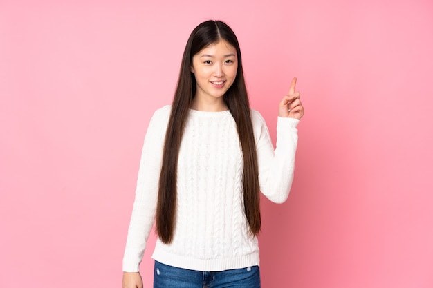 Jonge Aziatische vrouw over geïsoleerde achtergrond die en een vinger in teken van het beste tonen opheft
