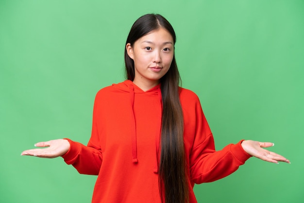 Jonge Aziatische vrouw over geïsoleerde achtergrond met twijfels