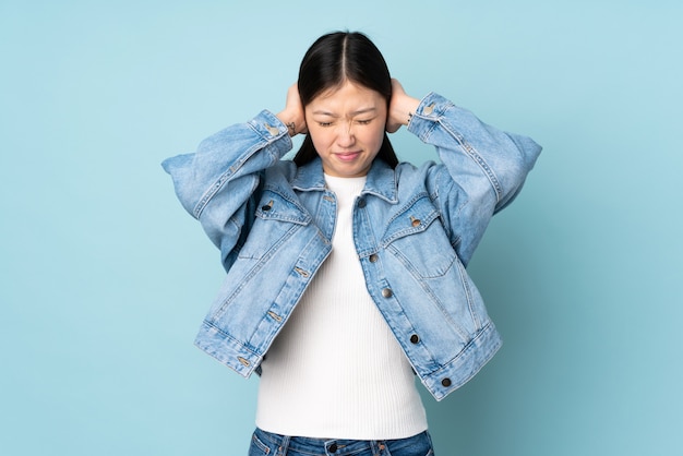 Jonge Aziatische vrouw over muur gefrustreerd en oren behandelen