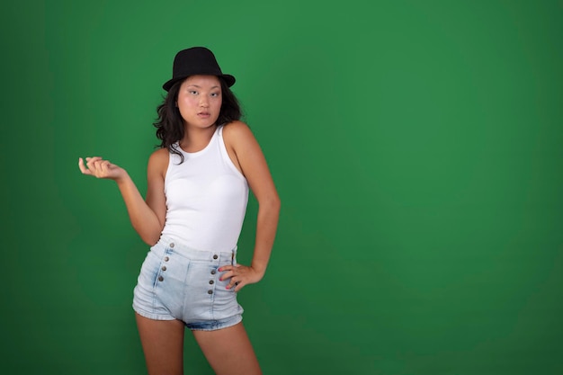 Jonge Aziatische vrouw poseren in korte broek tanktop en hoed