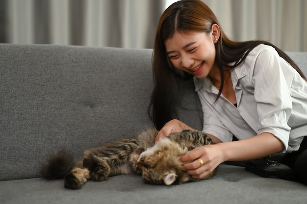 Jonge Aziatische vrouw speelt met haar kat