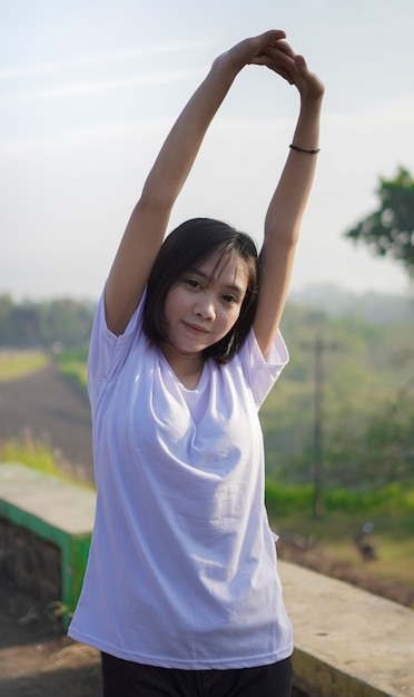 Jonge Aziatische vrouw strekt zich uit voordat ze 's ochtends gaat joggen en rennen
