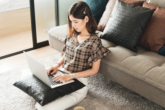 Jonge Aziatische vrouw thuis werken