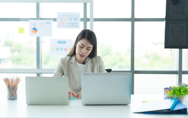 Jonge Aziatische vrouw werkt in een callcenter als adviseur over aandelenbeleggingen.