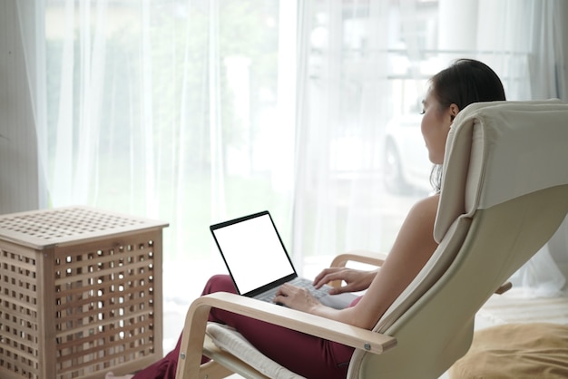 Foto jonge aziatische vrouw werkt vanuit huis met laptop als freelancer e-leerconcept